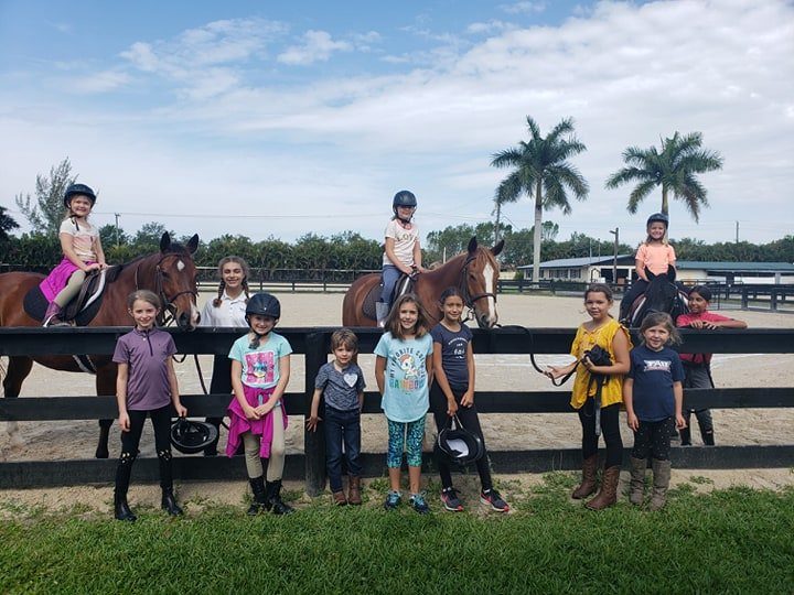 Campers lined up along the arena fence with their horses