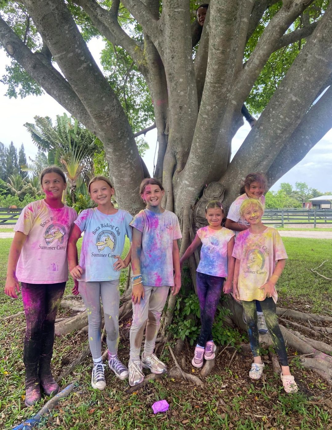 Campers covered in color powder under the big tree